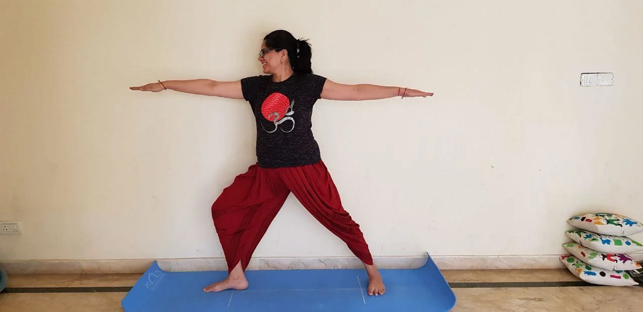 Shikha Dokania demonstrating Warrior II yoga pose – online yoga classes available across India